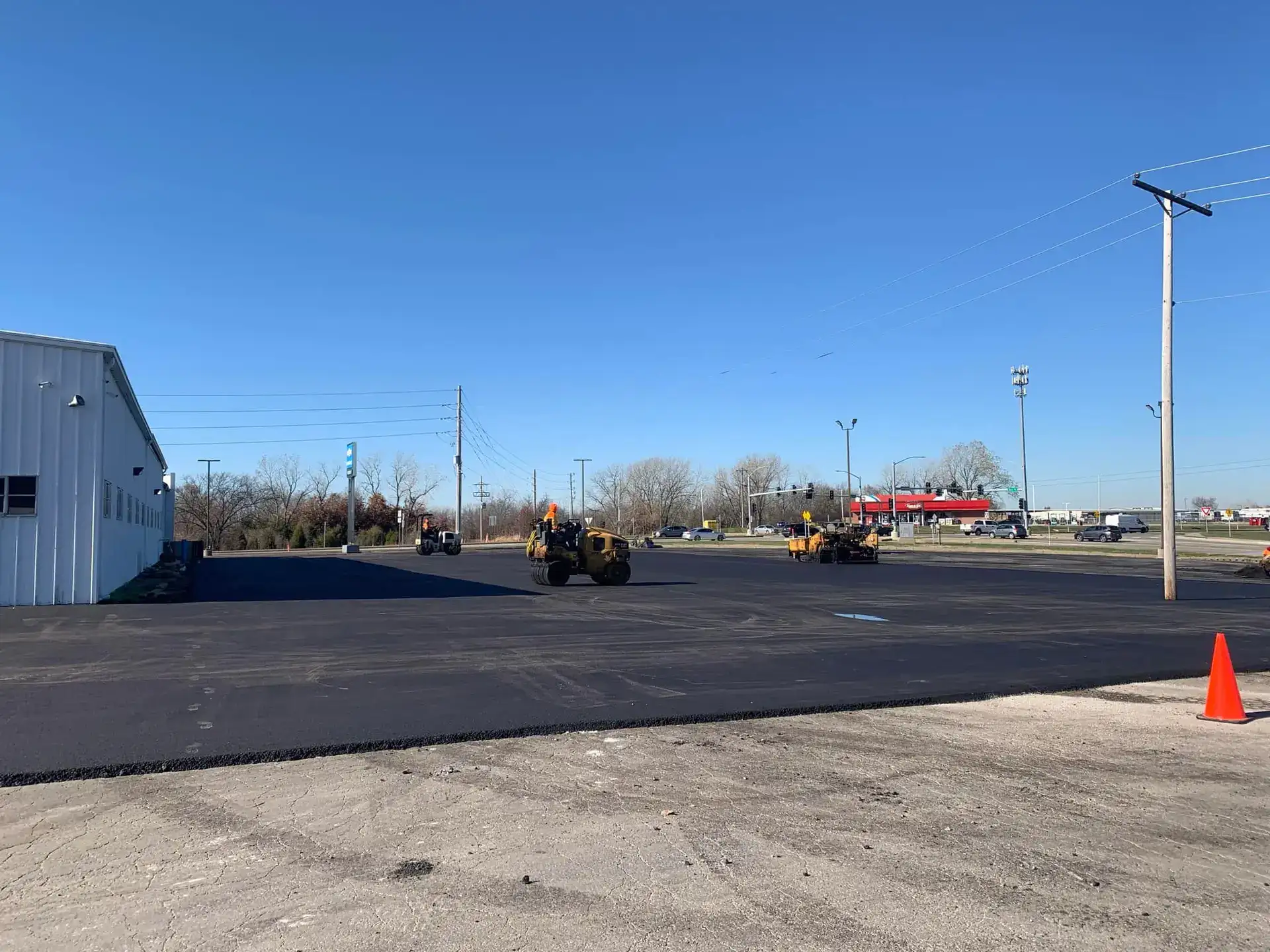 New asphalt paving by Platinum Paving — multiple rollers compacting hot mix on a Kansas City commercial lot